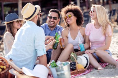 Bir grup insan bir iyi ruh hali ve sahilde piknik keyfi. Yaşam tarzı, eğlence, mutluluk ve tatil kavramı.