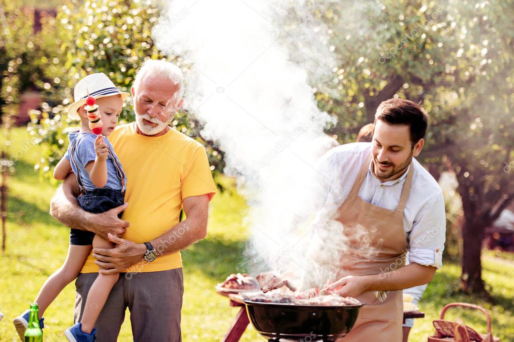 Happy family having barbecue party at summer garden.Leisure,family,holidays and people concept. 