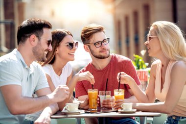 Grup dört arkadaşıyla birlikte bir kahve dükkanında eğleniyor. İki kadın ve iki erkek konuşuyor, gülüyor ve onların zaman zevk Café.