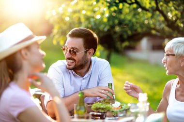 İki kuşak aile güneşli bir günde bahçede piknik yapmak için bir araya geldi..
