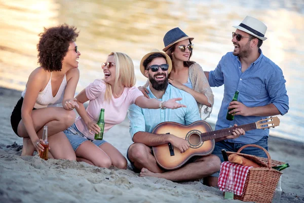 Friends drinking beers and listening to music.Having fun at beach party. Summer, holidays, vacation, music, happy people concept.