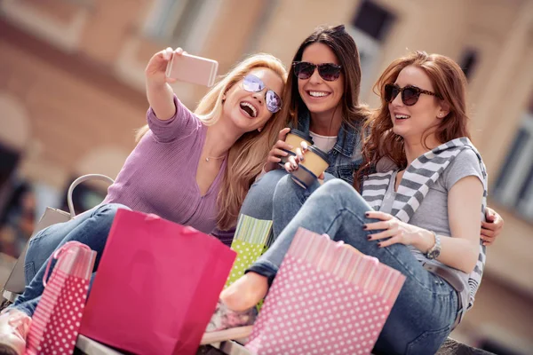 Happy friends shopping. Three beautiful young women enjoying shopping in the city.