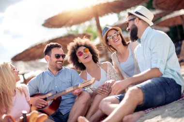 Sahilde eğleniyor ve gitar müzik arkadaş grubu.