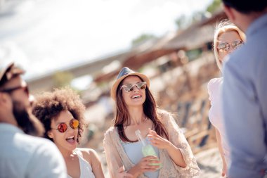Arkadaş birlikte sahilde zevk, soğuk bira içmek.