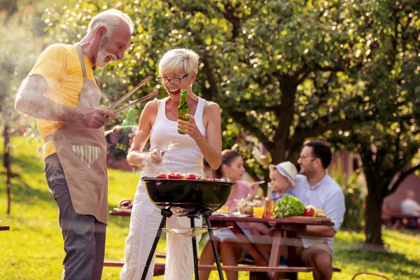 快乐的家庭在夏日花园里举行烧烤聚会 节假日和人的概念 — 图库照片