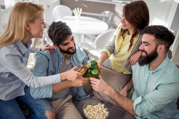 Group of friends sitting on the couch and eating popcorn.Friendship and party concept.