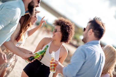 Arkadaş birlikte sahilde zevk, soğuk bira içmek.