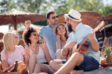 Sahilde eğleniyor ve gitar müzik arkadaş grubu.