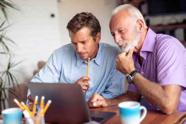 Modern ofiste yeni bir proje üzerinde çalışan iki işadamı.
