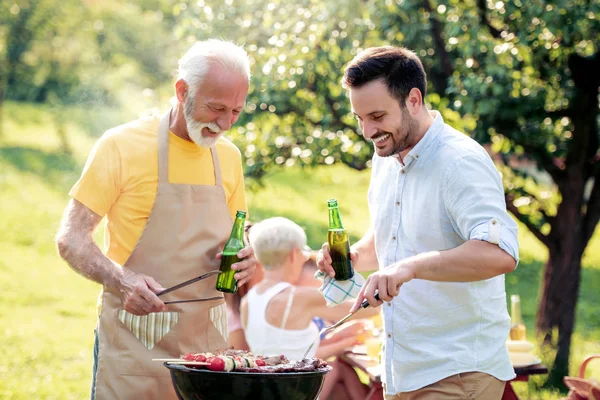 家族たちはバーベキュー パーティー彼らの庭で夏には ビールを飲むと楽しい時を過す — ストック写真