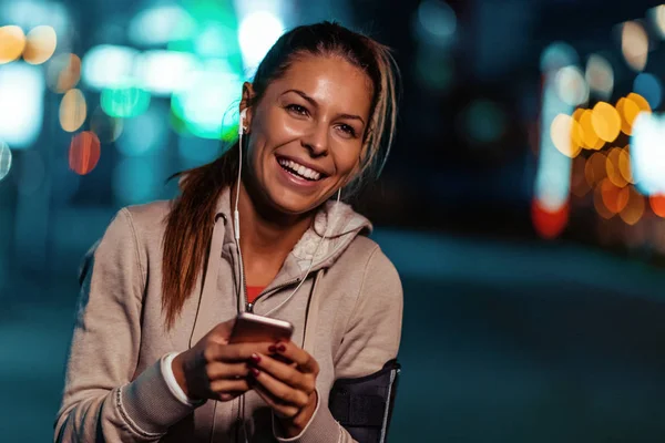 Young fitness woman jogging at night in the city.