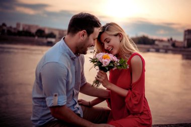 Nehir tarafından güzel günbatımı duygular paylaşımı aşk çift.