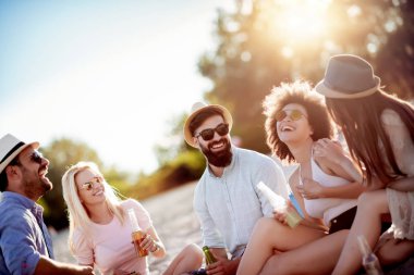 Plajda rahatlatıcı mutlu arkadaşlar. Plaj partisinde eğlenmek.