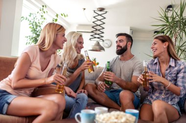 Genç arkadaşlar grup eğlenmek, bira içme ve evde popcorns yeme.