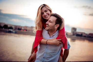 Açık havada aşık genç bir çift. Gün batımında kucaklaşan genç kadın ve adamın portresi. 