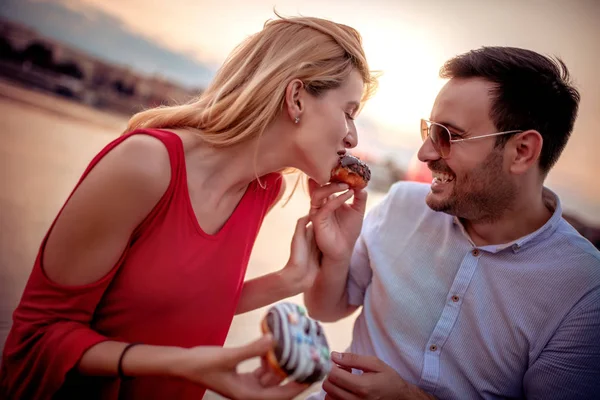 Happy Young Couple Having Fun Outdoors Eating Donuts — Stock Photo, Image