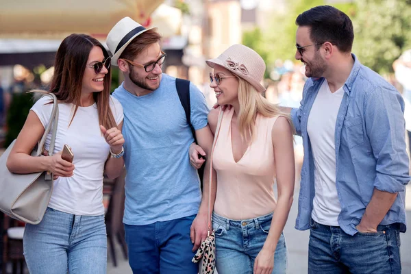 Group of young people walking through city. Friends having fun outdoors.