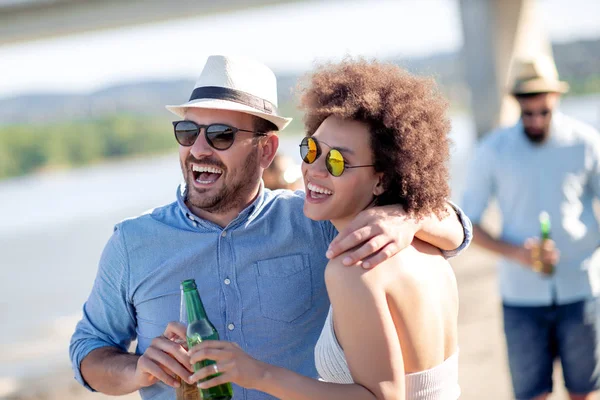 Plajda rahatlatıcı ve içme bira romantik çift.