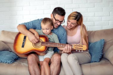 Evde birlikte zevk, gitar çalmak mutlu aile.