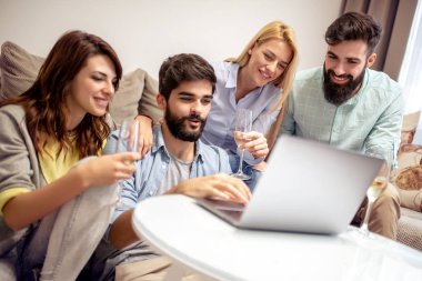 Birlikte kanepede oturan ve eğlenceli izlerken arkadaşlar video üstünde laptop.
