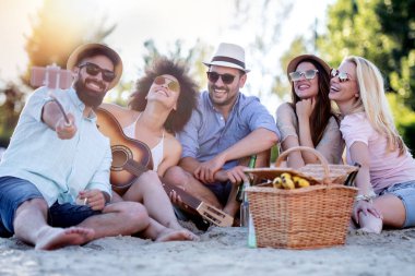 Yaz, tatil, tatil ve mutluluk konsept grubu arkadaşlar akıllı telefon ile selfie çekiyor.