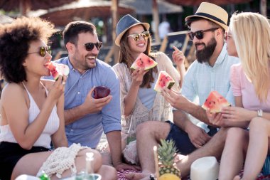 Arkadaşlar sahilde harika vakit geçiriyorlar, karpuz yiyorlar..