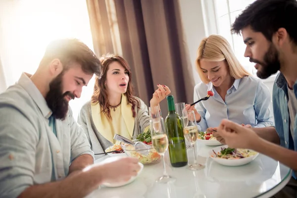 Friends meeting. Group of happy people with glasses,talking and eating healthy meals at party dinner.