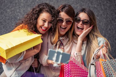Şehrin alışveriş torbaları ile üç güzel genç kadın. Satılık, moda, tüketim ve insanlar kavramı