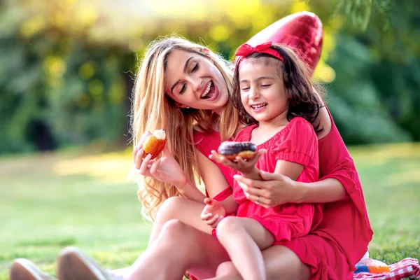 Lycklig Mamma Och Hennes Dotter Kul Äta Munk Medan Sitter — Stockfoto