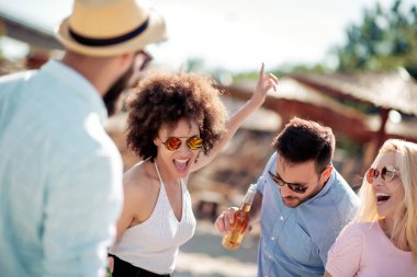 Grup arkadaşıyla sahilde parti. Gençler yaz tatili kutluyor.