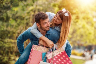 Güzel, genç bir çift alışveriş torbaları taşıyor ve birlikte eğleniyorlar..