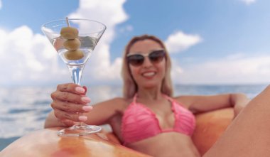 Plajda bikinili güzel bir kadının kokteylin tadını çıkaran portresi.