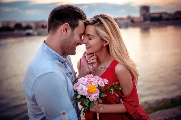 Gün batımında eğlenen mutlu bir genç çiftin portresi.