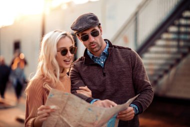 Şehirde harita yı kullanan mutlu çift turist.