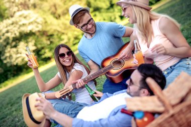 Bir parkta piknik yaparken bir grup arkadaş, piknik partisinin tadını çıkarıyorlar.. 