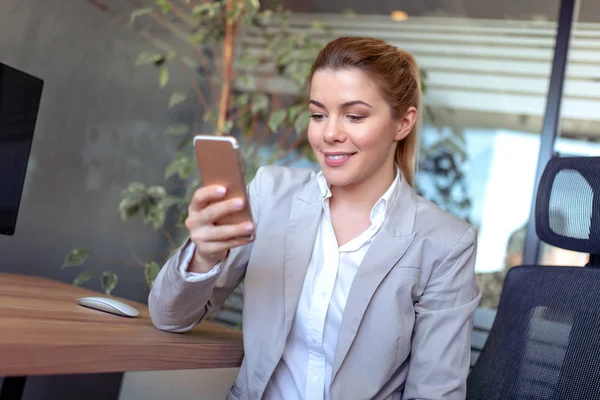 Young woman with mobile phone in the office.