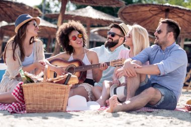 Gençlerin grup birlikte eğleniyor sahilde, piknik mutlu.