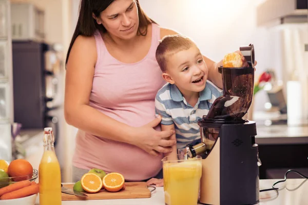 Madre Embarazada Hijo Disfrutando Cocina Haciendo Jugo Naranja Fresco —  Fotos de Stock