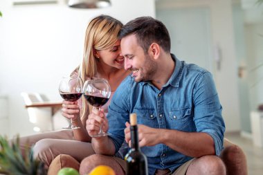 Mutlu genç çift evde birlikte romantik bir gün geçirmek, kırmızı şarap içme.