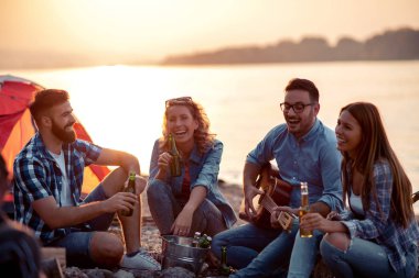 Heyecanlı arkadaşlar sahilde eğlenmek, gitar çalmak grup.