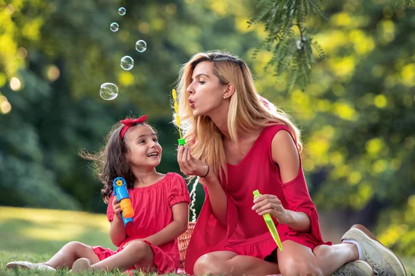 Beautiful Mother Her Daughter Blowing Soap Bubbles Park — Stock Photo, Image