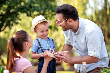 Aile dışarıda öğle yemeği yiyor ve birlikte eğleniyor. Eğlence, tatil, yeme, insanlar ve gıda kavramı.