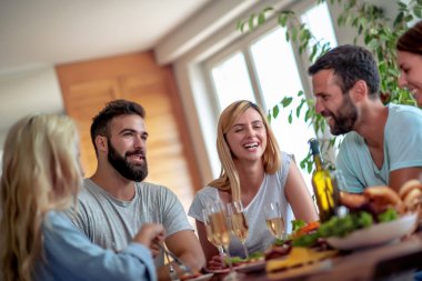 Genç arkadaşlar şarap ve yemekle birlikte harika vakit geçirip kutlama yapar..