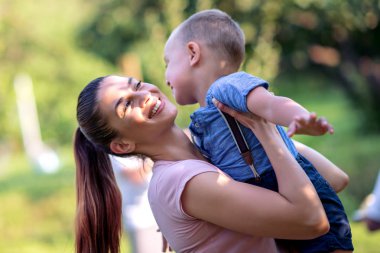 Genç anne ve küçük oğlu parkta eğleniyor.