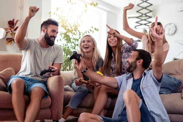 Konsolda video oyunları oynayan arkadaşlar, birlikte eğleniyor.