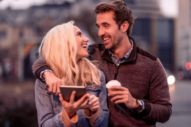 Gülümseyen sevimli çift şehir caddesinde selfie çekiyor.