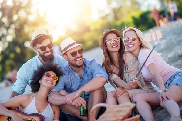 Sahilde birlikte eğlenen arkadaşlar, selfie çekiyorlar.