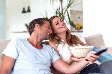 Mutlu genç çift evde film izlemeye hazırlanıyor..
