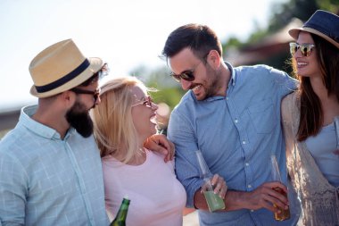 Sahilde birlikte eğlenen arkadaşlar, soğuk bira ve tost içme.