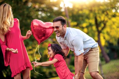 Mutlu bir genç aile yaz günü dışarıda vakit geçirir..